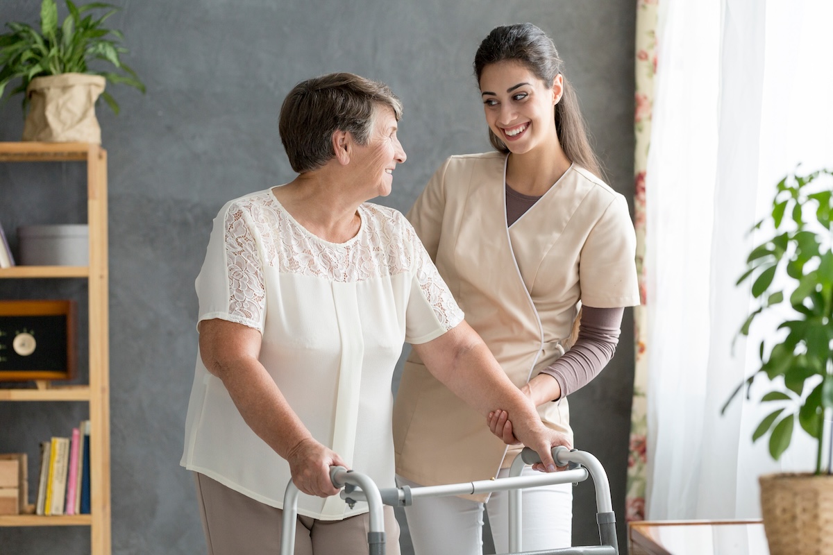 An image of a caregiver gladly helping an elderly woman represents quality home care in New Rochelle.