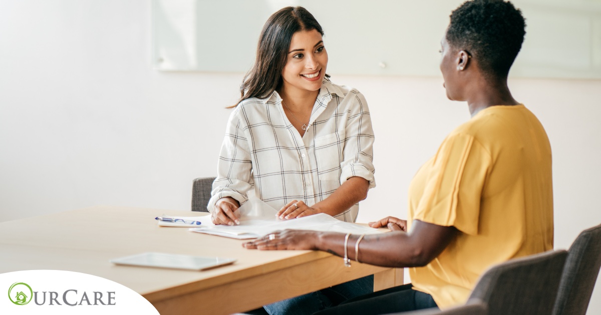 A woman smiles while being interviewed representing how well a caregiver interview can go when good questions are asked.