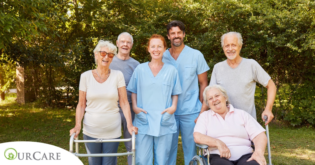 2 caregivers and seniors smile while in a group representing how caregivers can facilitate socialization.